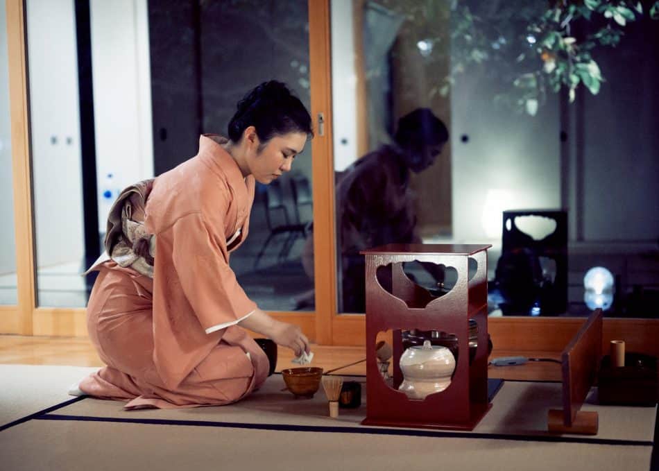 Woman prepares to serve tea during Japanese tea ceremony